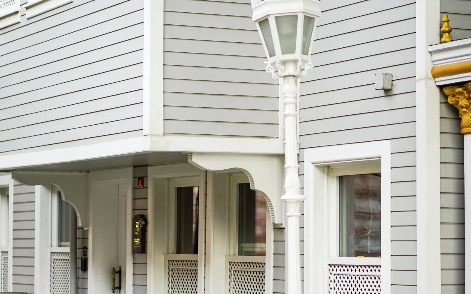 Detailed gray residential siding with crisp white exterior trim